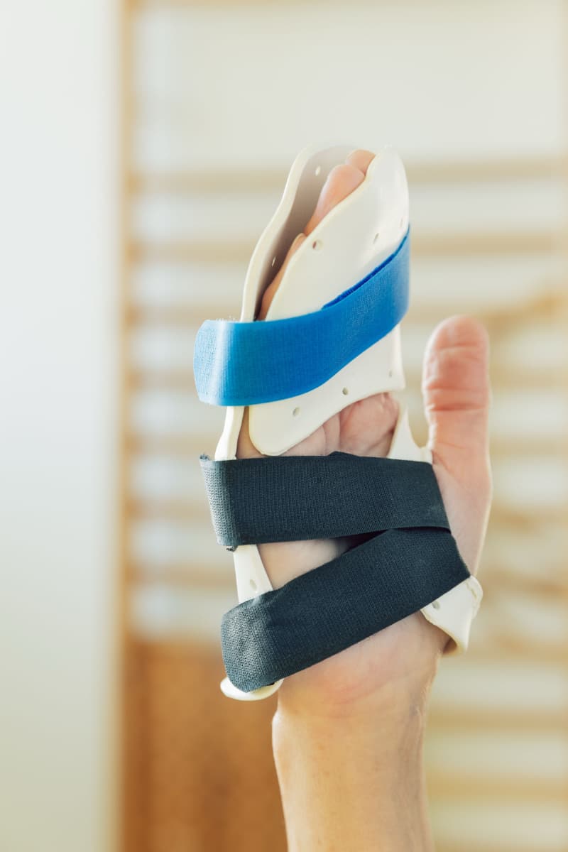 Hand mit alle Finger bedeckender Schiene